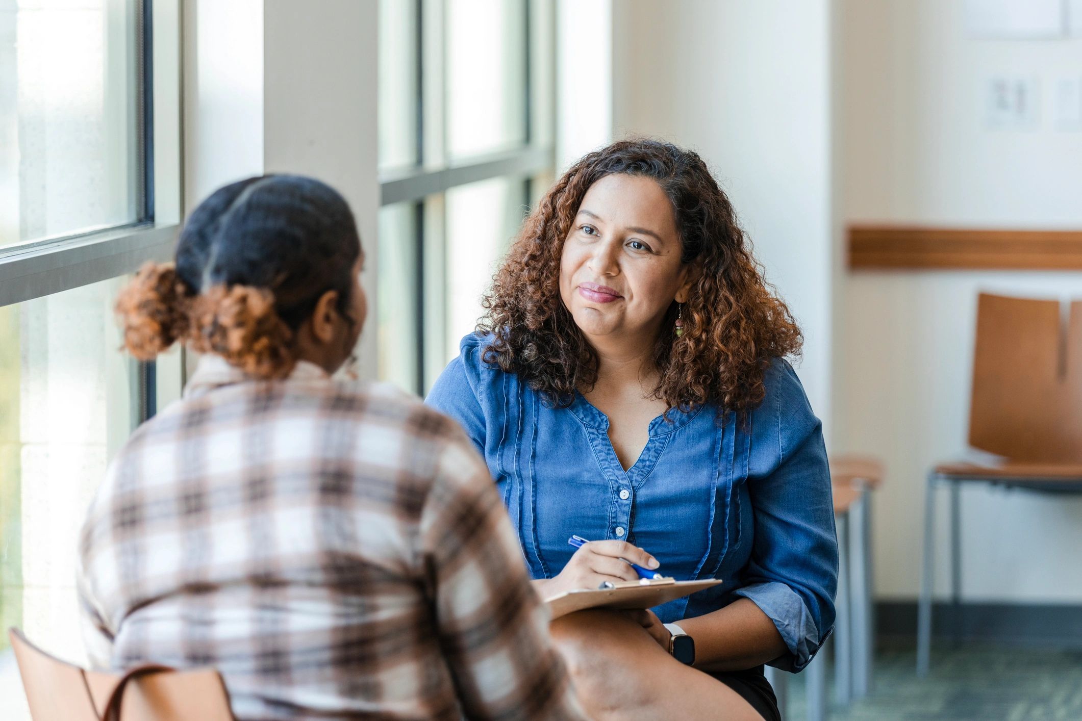 Support staff speaking with a client in a private setting